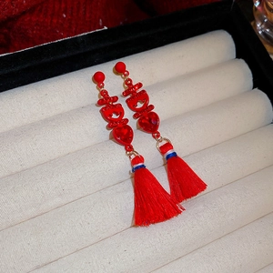 Detail of red Chinese Xi character earrings with heart crystal and long silk tassels