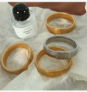 Detailed macro view of spiral spring-style metal bracelets in gold and silver finishes