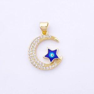 Macro shot of gold crescent moon and blue evil eye star charm with zircon inlay