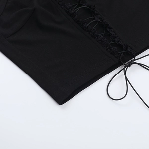 Detailopname van de zwarte crop top met kris-kras vetersluiting en ruches aan de rand
