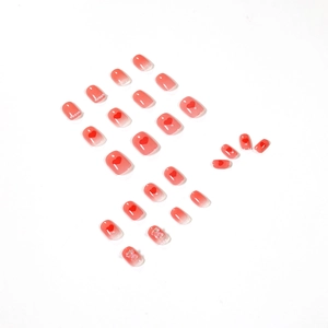 Pink gradient press-on nails with red hearts, pearls, and 3D bowknot accents