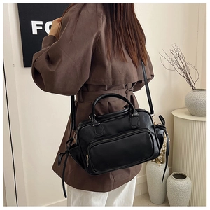 Rear view of a black PU leather backpack with side ribbon knots and dual zippers on a model