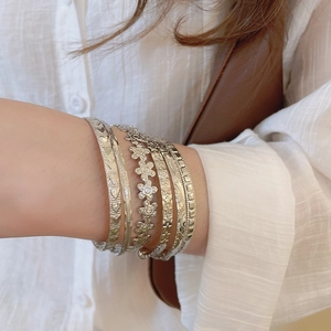 Détail du lot de bracelets argentés avec fleurs et étoiles portés au poignet
