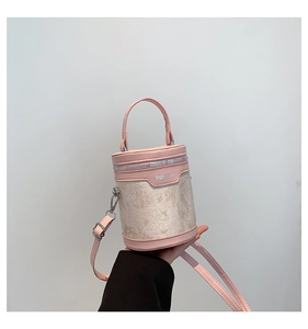 Detail view of pink PU leather and beige jacquard fabric on stylish bucket bag
