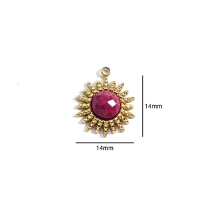 Detail of 14mm sunburst gold pendant with a faceted red gemstone center for DIY jewelry