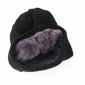 Detailed view of winter beanie showing thick black knit exterior and purple fleece lining