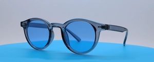 Detailansicht runder Retro-Sonnenbrillen mit blauen Gläsern und transparentem grauem Rahmen