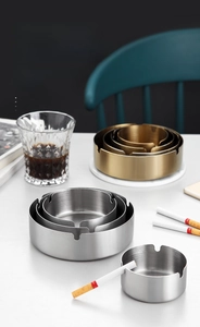 Detail of thickened gold stainless steel ashtray with brushed texture and U-shaped slots