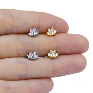 Macro shot of cat paw nose studs with pink and white zircon in gold and silver plating