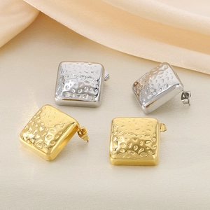 Detailansicht quadratischer Hammerschlag-Ohrringe in Gold und Silber auf Seide