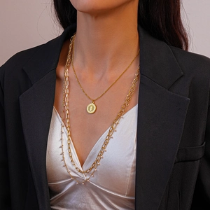 Detail of 18K gold plated double layer sun coin necklace with rectangle links on a model