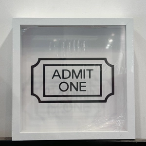 Close-up of white wooden memory box with Admit One cinema ticket design and protective film