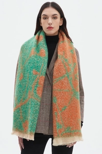 Detailed view of winter jacquard scarf with green floral pattern and short soft tassels