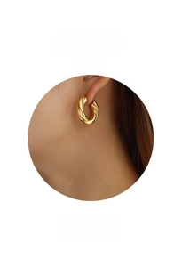 Detail view of model wearing polished 18K gold twisted hoop earrings, item F435