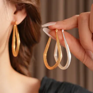 Boucles d'oreilles créoles larmes en or et argent mat avec finition métal sablé