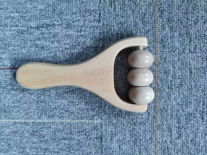 Detailaufnahme des ergonomischen Holzgriffs und der drei glatten Massagerollen