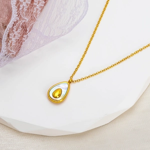 French avocado-shaped shell pendant necklace in gold titanium steel on beige silk fabric