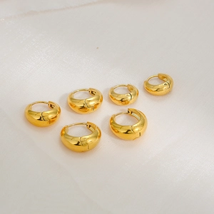 Three pairs of elegant chunky gold huggie hoop earrings made of polished stainless steel