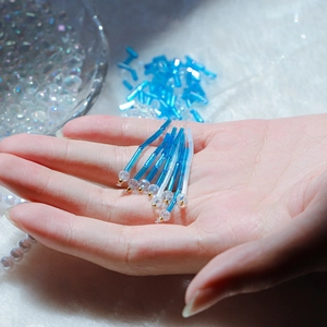 Macro detail of blue glass bugle beads with faceted crystals for DIY jewelry making