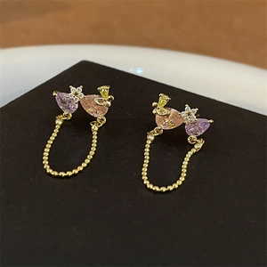 Detail of vintage palace style earrings with pink drop zircons and golden bead chains