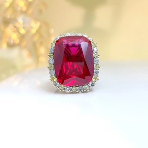 Luxury pigeon blood ruby ring with rectangle cut stone and yellow diamond halo accents