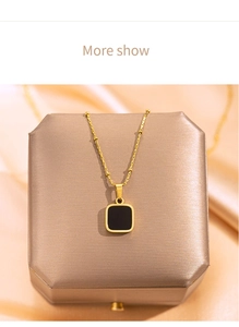 Macro detail of a 18k gold-plated chain with a minimalist black square pendant