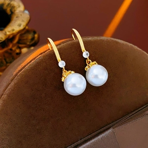 Detailed macro view of 14K gold plated earring with white pearl and sparkling zircon