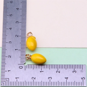 Detailed view of yellow lemon charms with metal ruler showing 1.5cm size measurement