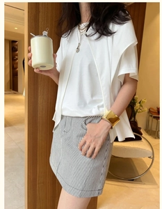 Polished gold wide cuff bracelet styled with minimalist striped skirt and white t-shirt
