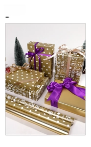Detail of premium gold Christmas wrapping paper with white polka dots and festive lettering