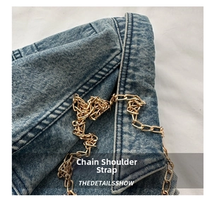 Close-up of washed blue denim bag featuring a vintage gold thick chain shoulder strap