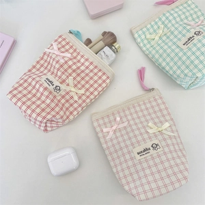 Detail of plaid cosmetic bags with bow knots and zipper, showing interior storage capacity