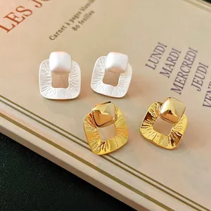 Minimalist square geometric stud earrings with textured gold and silver metal finishes