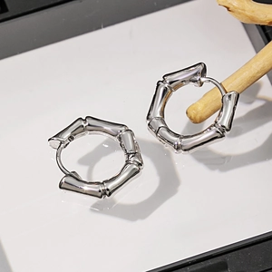 Détail de boucles d'oreilles en argent style bambou avec texture métallique polie