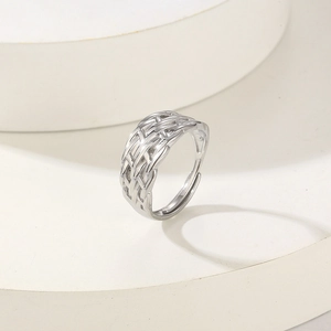 Minimalist silver woven mesh titanium steel open ring on a geometric white pedestal