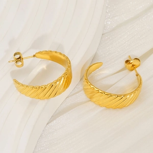 Macro detail of gold 18K stainless steel hoop earrings with elegant textured ridge design