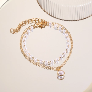 Detail of baroque pearl bracelet showing double-layer golden chain and lobster clasp