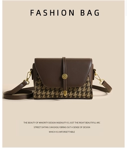 Macro detail of houndstooth fabric stitching and golden circular clasp on brown crossbody bag