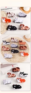 Detailed view of cute cartoon cat and dog claw clips made of glossy acetate material