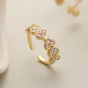 Detail of copper open ring with pink and clear heart-shaped cubic zirconia inlay