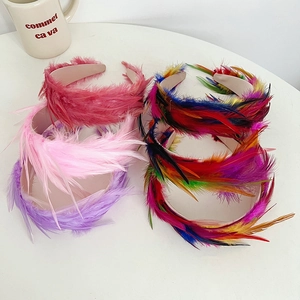 Detail showing five colorful feather headbands with vibrant textures on a white surface