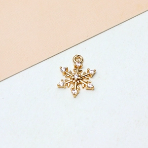Makroaufnahme von Gold-Schneeflocken-Anhänger mit Zirkonia-Steinen und Öse für DIY-Schmuck