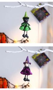 Detail of plush Halloween witch dolls with cat and old crone features hanging from dry branches