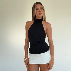 Detail of black halter neck knitted top with slim fit design and backless cut