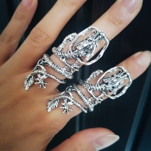 Macro detail of silver dragon ring showing intricate metal scales and retro punk textures