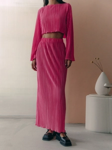 Detail of rose pink pleated fabric texture on chic flared sleeve crop top and long skirt