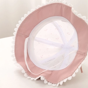Detailansicht eines rosa Baby-Sonnenhuts mit Spitzenrand und Herz-Print-Innenfutter