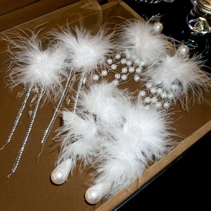 Detailed shot of elegant feather and pearl earrings on premium brown velvet jewelry box