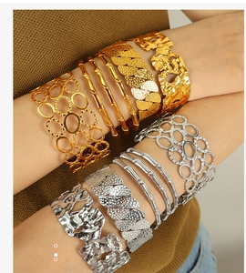 Detail of 18k gold and silver hollow bamboo bracelets on model's wrist