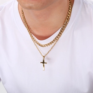 Détail d'un collier à deux rangs en acier doré avec croix sur un mannequin homme